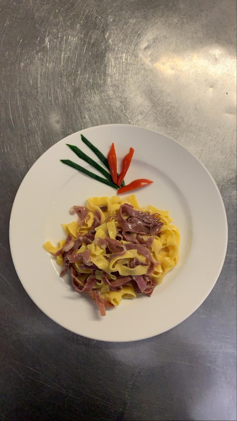 Piatto di tagliatelle fresche fatte in casa con prosciutto